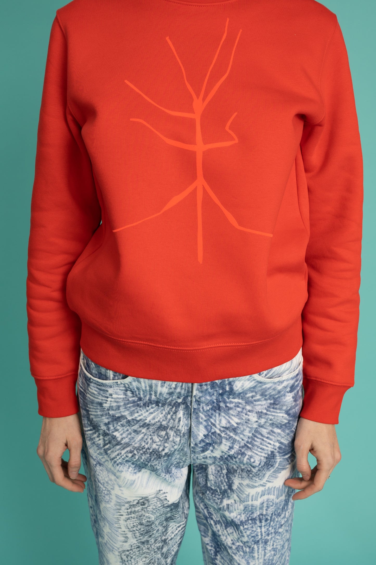 A slightly orange-red sweater and a walking stick