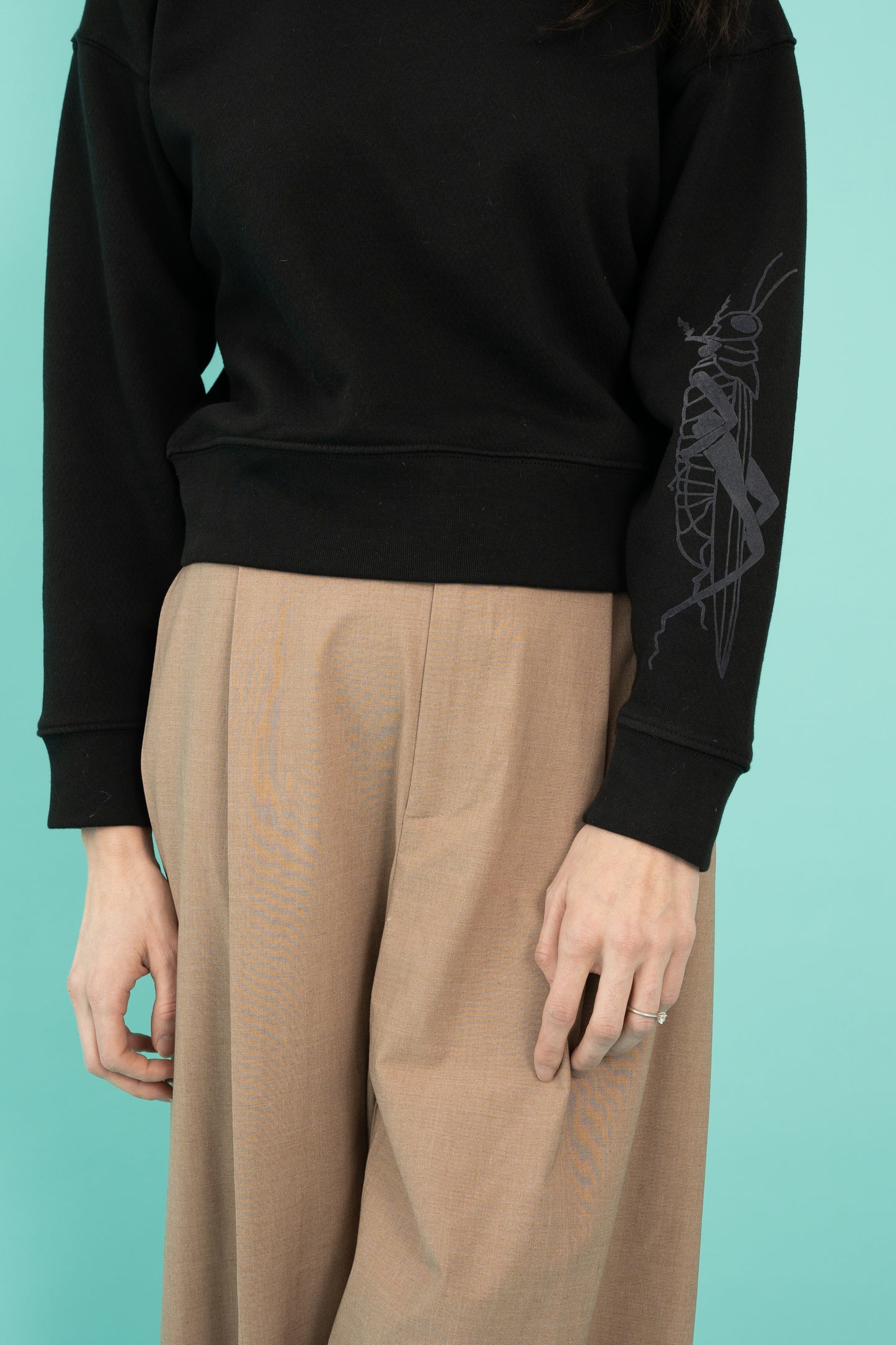 Black cropped crew neck sweatshirt with a grasshopper on the sleeve