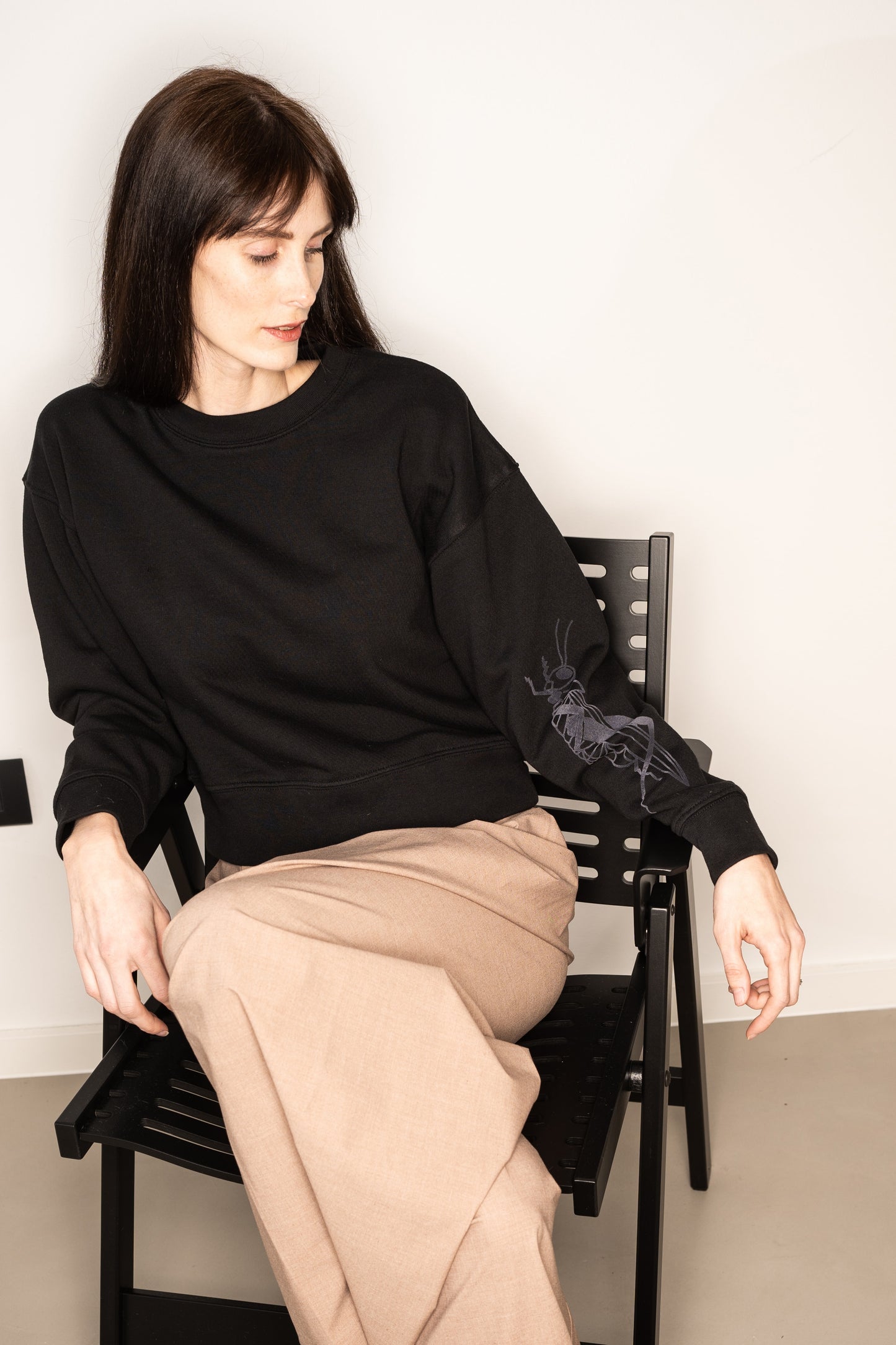 Black cropped crew neck sweatshirt with a grasshopper on the sleeve