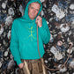 Turquoise hoodie and a walking stick in front