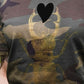 Golden scarab with black plush heart on a military pattern tee
