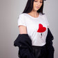 Woman's tee with fly holding a red plush heart 