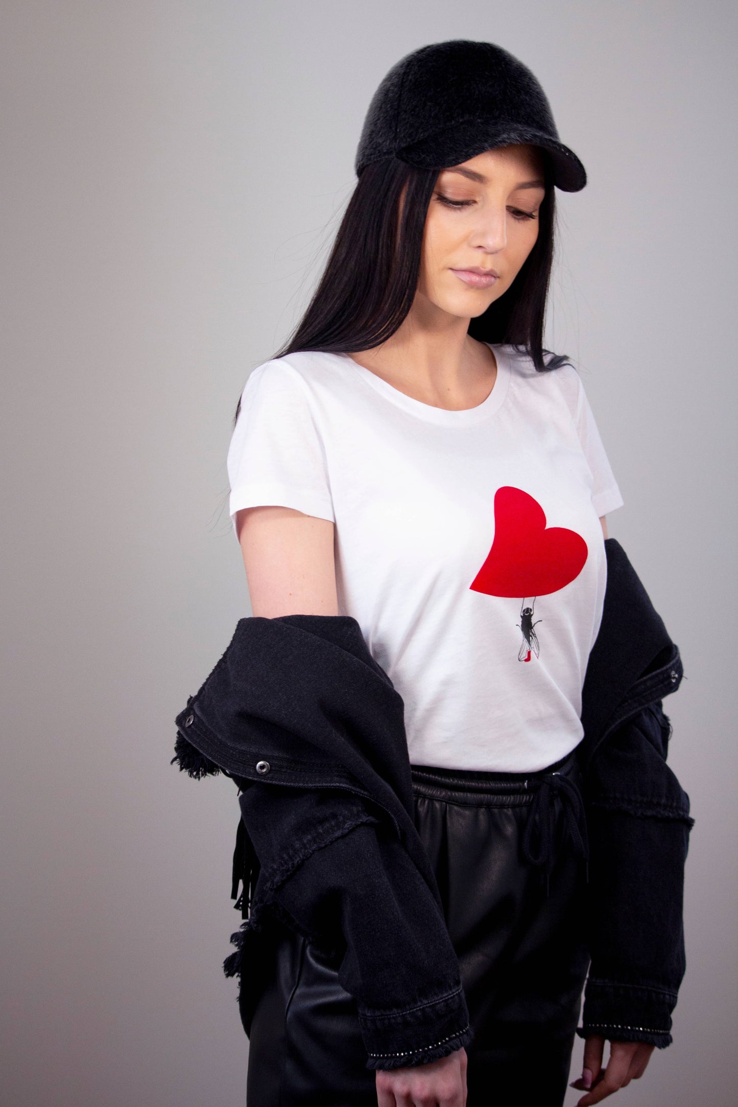 Woman's tee with fly holding a red plush heart 
