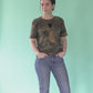 Golden scarab with black plush heart on a military pattern tee